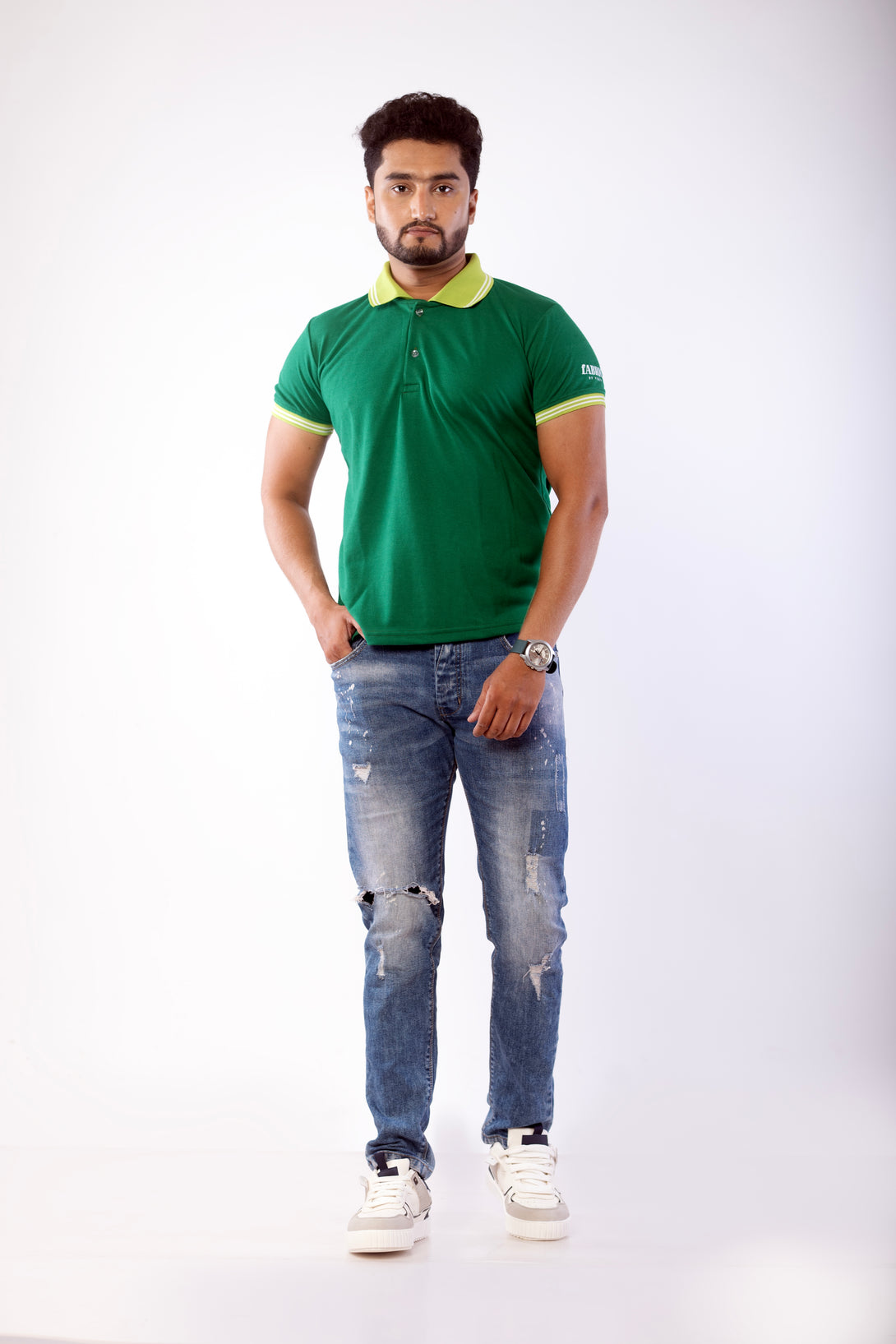 Man wearing a green polo shirt and blue jeans on a white background