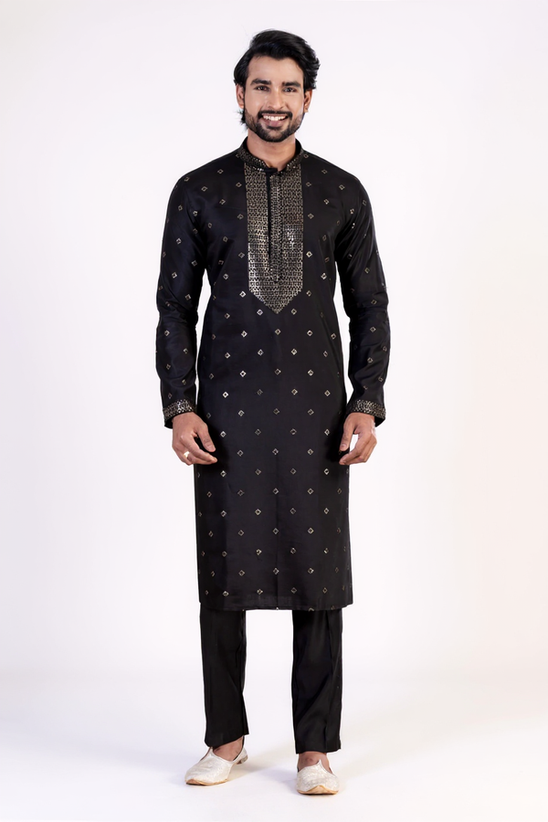 Man wearing a black kurta with white patterns on a white background