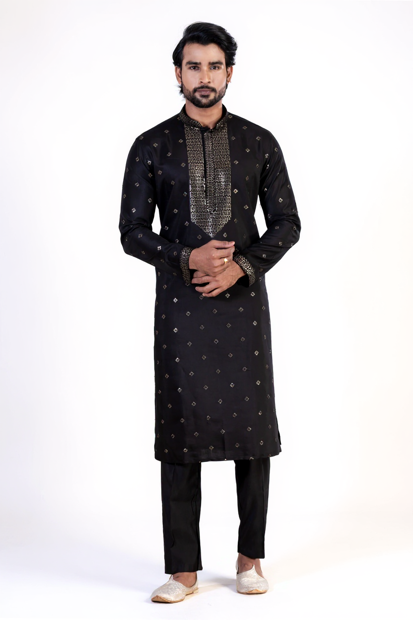 Man wearing a black traditional outfit with intricate patterns on a white background